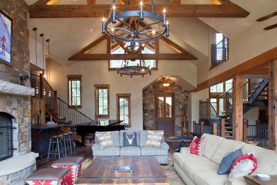 Mid-sized mountain style open concept dark wood floor family room photo in Denver with a bar, beige walls, a standard fireplace, a stone fireplace and a wall-mounted tv