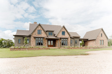 Huge green two-story brick exterior home photo in Austin with a shingle roof and a brown roof