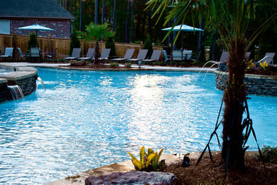 Huge elegant backyard concrete paver and custom-shaped lap hot tub photo in Jackson