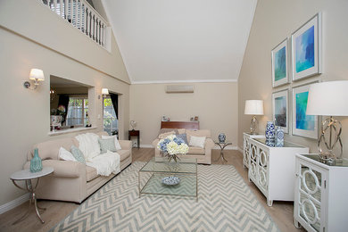 Mid-sized beach style formal open concept living room in Perth with light hardwood floors, a standard fireplace, a wood fireplace surround and beige walls.
