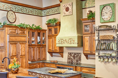 Inspiration for a mid-sized transitional u-shaped eat-in kitchen in Austin with an integrated sink, raised-panel cabinets, medium wood cabinets, granite benchtops, panelled appliances and with island.
