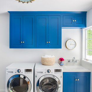 Imagen de cuarto de lavado lineal, clásico renovado, con fregadero bajoencimera, armarios estilo shaker, puertas de armario azules, paredes grises, lavadora y secadora juntas y suelo gris