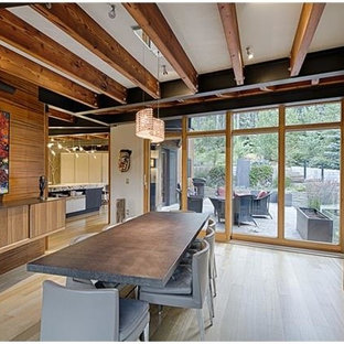 Réalisation d'une salle à manger ouverte sur le salon minimaliste de taille moyenne avec un mur blanc, un sol en bois clair, une cheminée ribbon, un manteau de cheminée en bois et un sol beige.