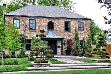 Elegant brick exterior home photo in Houston with a hip roof