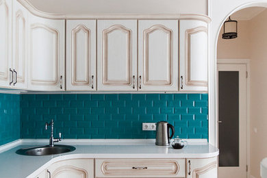 Inspiration for a mid-sized country l-shaped ceramic tile eat-in kitchen remodel in Moscow with an undermount sink, raised-panel cabinets, distressed cabinets, solid surface countertops, blue backsplash, subway tile backsplash and paneled appliances