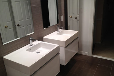 Mid-sized trendy master brown tile and ceramic tile ceramic tile bathroom photo in New York with furniture-like cabinets, white cabinets, solid surface countertops, a console sink and brown walls
