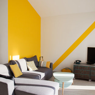 Immagine di un piccolo soggiorno contemporaneo aperto con pavimento grigio, pareti gialle, TV autoportante e nessun camino