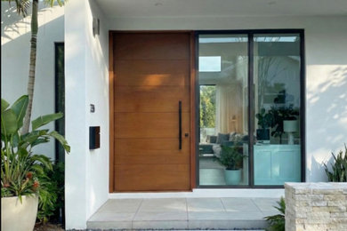 Inspiration for a large modern entryway remodel in Miami with a light wood front door