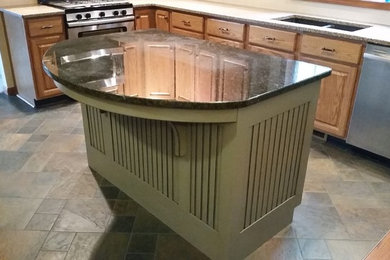 Mid-sized elegant l-shaped slate floor enclosed kitchen photo in Other with an undermount sink, beaded inset cabinets, granite countertops, an island, light wood cabinets and stainless steel appliances