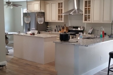 Kitchen - mid-sized traditional l-shaped ceramic tile kitchen idea in Jacksonville with a single-bowl sink, granite countertops, stainless steel appliances and an island