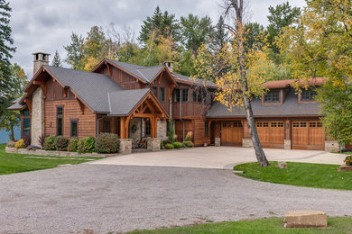 Large mountain style brown two-story wood exterior home photo in Other with a shingle roof