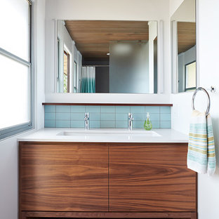 Ispirazione per una stanza da bagno minimalista con ante lisce, ante in legno scuro, piastrelle blu, pareti bianche, lavabo sottopiano, pavimento grigio e top bianco