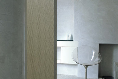 Inspiration for a large contemporary ensuite bathroom in London with flat-panel cabinets, white cabinets, a built-in bath, a built-in shower, a wall mounted toilet, white tiles, mosaic tiles, grey walls, pebble tile flooring, a wall-mounted sink, glass worktops, white floors, an open shower and white worktops.