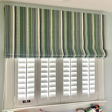Room Darkening Roman Shade using Schumacher Fabric over White Plantation Shutter