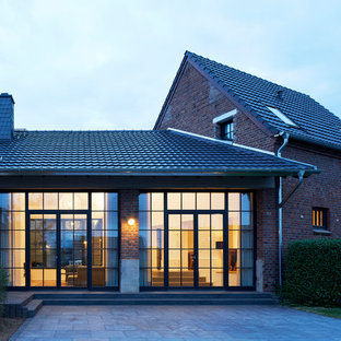 Großes, Zweistöckiges, Rotes Rustikales Einfamilienhaus mit Backsteinfassade, Satteldach und Ziegeldach in Köln