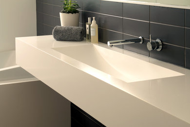 This is an example of a modern bathroom in Sydney with solid surface benchtops.