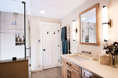Mid-sized transitional master beige tile and porcelain tile porcelain tile corner shower photo in Portland Maine with an undermount sink, shaker cabinets, medium tone wood cabinets, quartz countertops, beige walls and a two-piece toilet