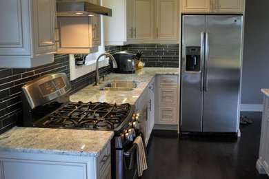 Example of a large classic galley dark wood floor eat-in kitchen design in Toronto with an undermount sink, shaker cabinets, white cabinets, granite countertops, gray backsplash, stainless steel appliances and an island