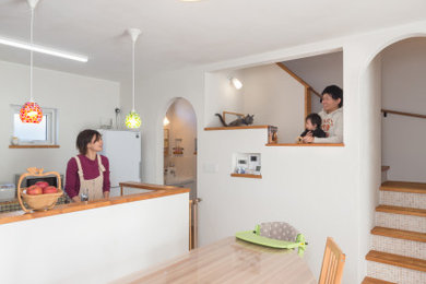 Diseño de comedor blanco abierto sin chimenea con paredes blancas, suelo de madera en tonos medios y suelo marrón