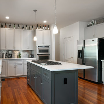 Platinum Gray Kitchen with a Graphite Gray Island and White and Gray Quartz Tops