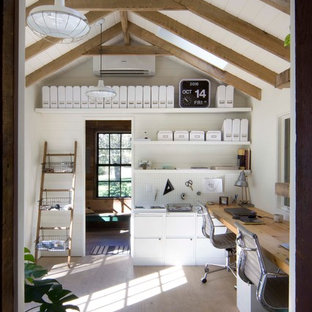 Inredning av ett lantligt arbetsrum, med vita väggar, ljust trägolv och ett inbyggt skrivbord