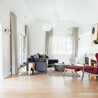 This is an example of a medium sized mediterranean open plan living room in Salt Lake City with white walls, medium hardwood flooring, a standard fireplace, a tiled fireplace surround and no tv.