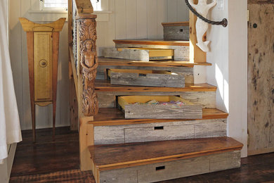 Large beach style wooden curved wood railing staircase photo in Boston with wooden risers