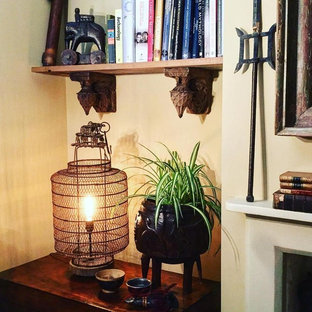 Foto di una camera degli ospiti etnica di medie dimensioni con pareti gialle, moquette, camino classico, cornice del camino in legno e pavimento beige