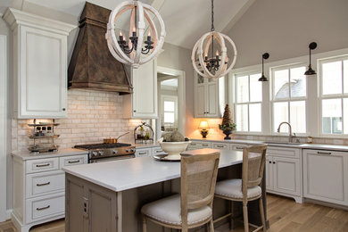 Kitchen - mid-sized country l-shaped light wood floor and beige floor kitchen idea in Other with beige backsplash, an island, an undermount sink, recessed-panel cabinets, white cabinets and brick backsplash