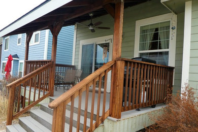 Inspiration for a mid-sized back porch remodel in Other with a roof extension and decking