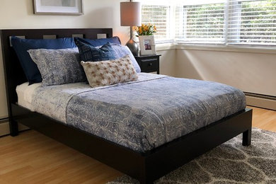 Mid-sized minimalist guest light wood floor and brown floor bedroom photo in Baltimore with beige walls and no fireplace
