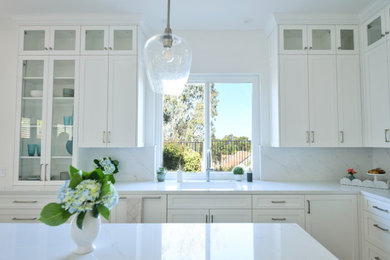 Inspiration for a mid-sized coastal vinyl floor and brown floor eat-in kitchen remodel in San Diego with an undermount sink, shaker cabinets, white cabinets, quartz countertops, white backsplash, paneled appliances and white countertops