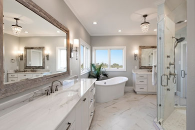 Design ideas for a transitional master bathroom in Dallas with recessed-panel cabinets, white cabinets, a freestanding tub, an alcove shower, white tile, porcelain tile, grey walls, porcelain floors, marble benchtops and an undermount sink.