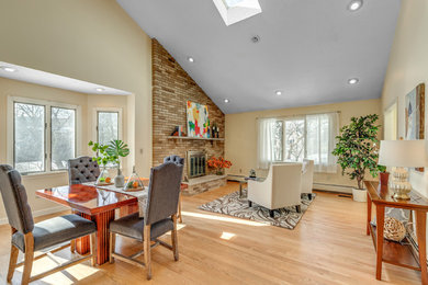 Inspiration for a mid-sized timeless light wood floor and beige floor great room remodel in Boston with yellow walls, a standard fireplace and a brick fireplace