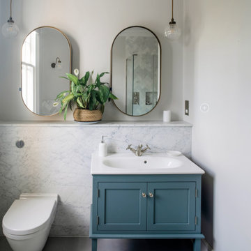 Family bathroom with blue vanity and double pebble mirrors