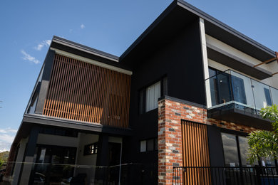 Large contemporary two-storey brick house exterior in Brisbane with a flat roof, a metal roof and a grey roof.