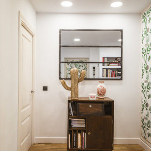 Inspiration för en liten tropisk hall, med vita väggar och mellanmörkt trägolv