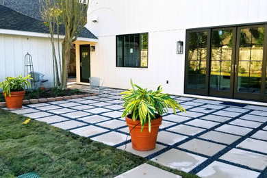 Diseño de jardín moderno de tamaño medio en verano en patio trasero con roca decorativa, exposición parcial al sol y adoquines de hormigón