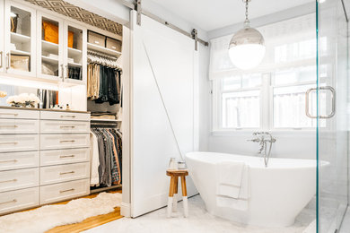 Inspiration for a mid-sized transitional gender-neutral medium tone wood floor, brown floor and wallpaper ceiling walk-in closet remodel in San Francisco with shaker cabinets and white cabinets