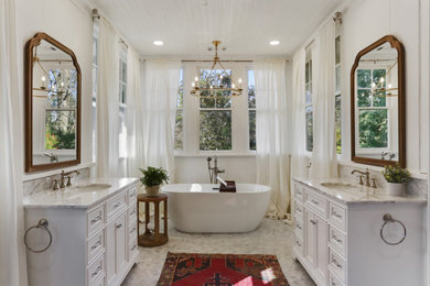 Example of a large classic master subway tile white floor, double-sink and wood ceiling freestanding bathtub design in Atlanta with white cabinets, white walls, an undermount sink, white countertops and a freestanding vanity