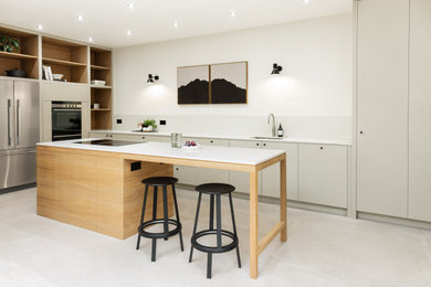 Design ideas for a medium sized contemporary grey and brown l-shaped open plan kitchen in Edinburgh with a single-bowl sink, flat-panel cabinets, light wood cabinets, quartz worktops, white splashback, marble splashback, stainless steel appliances, cement flooring, an island, grey floors and feature lighting.