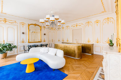 Diseño de salón abierto y beige y blanco grande con paredes beige, suelo de madera clara, todas las chimeneas y marco de chimenea de piedra