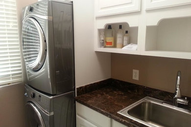 Inspiration for a mid-sized timeless galley utility room remodel in Las Vegas with a drop-in sink, raised-panel cabinets, white cabinets, beige walls, a stacked washer/dryer and granite countertops