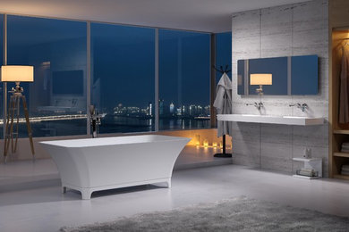 Example of a large trendy master gray floor freestanding bathtub design in Los Angeles with gray walls, a wall-mount sink, solid surface countertops and white countertops