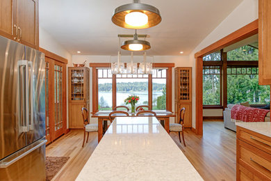 Mid-sized transitional u-shaped medium tone wood floor, brown floor and vaulted ceiling eat-in kitchen photo in Seattle with a double-bowl sink, recessed-panel cabinets, light wood cabinets, quartz countertops, blue backsplash, ceramic backsplash, stainless steel appliances, an island and white countertops