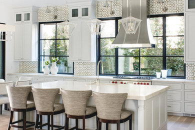 Inspiration for a mid-sized mediterranean l-shaped eat-in kitchen in Dallas with an undermount sink, recessed-panel cabinets, grey cabinets, quartzite benchtops, beige splashback, ceramic splashback, coloured appliances, light hardwood floors, with island, beige floor and beige benchtop.