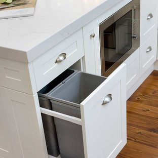 Large traditional kitchen pantry pictures - Example of a large classic u-shaped medium tone wood floor and beige floor kitchen pantry design in Hobart with a farmhouse sink, shaker cabinets, white cabinets, granite countertops, white backsplash, subway tile backsplash, stainless steel appliances, no island and white countertops