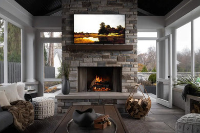 Inspiration for a large transitional concrete floor and gray floor sunroom remodel in Detroit with a standard fireplace and a stone fireplace