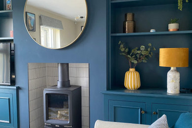 Design ideas for a medium sized traditional living room in Belfast with dark hardwood flooring, a wood burning stove, a wall mounted tv and panelled walls.