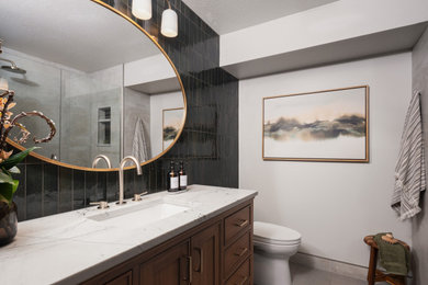 Inspiration for a mid-sized transitional 3/4 porcelain tile and green tile porcelain tile, gray floor and single-sink alcove shower remodel in Seattle with medium tone wood cabinets, a one-piece toilet, gray walls, an undermount sink, quartzite countertops, a hinged shower door, white countertops, a freestanding vanity and recessed-panel cabinets